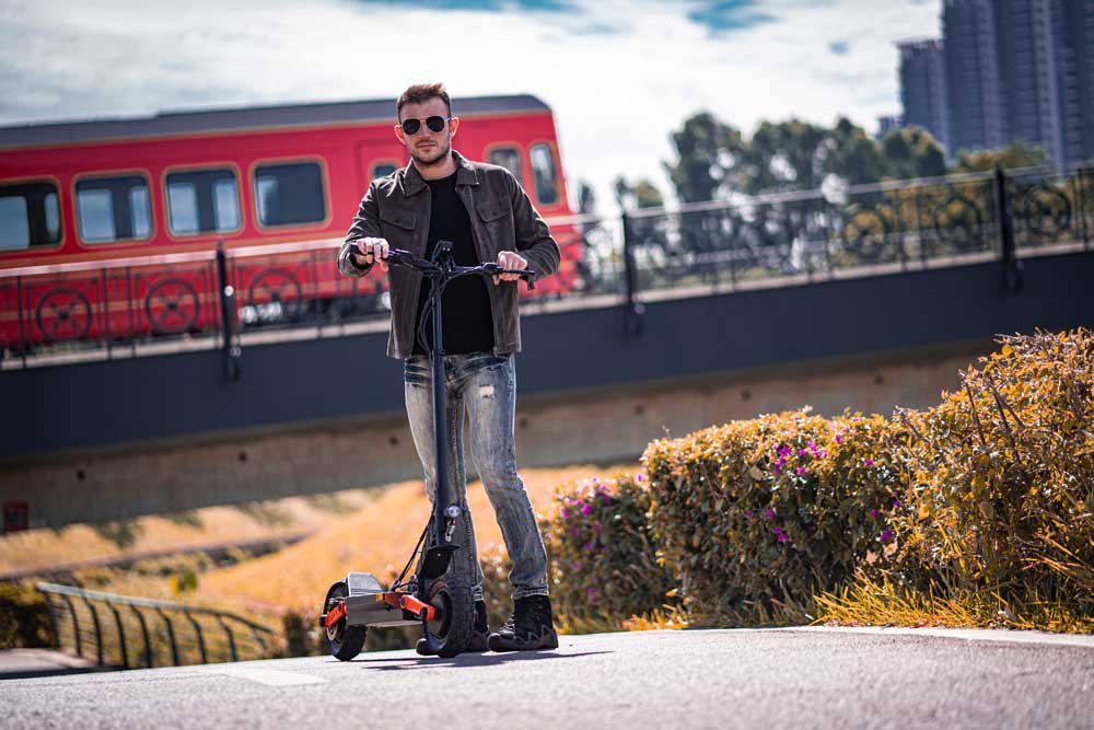Scooter eléctrico Joyor deslizándose por la ciudad, movilidad rápida, estilo urbano.
